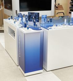 two white and blue coolers sitting next to each other in front of a tv