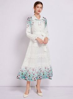 Captivating and ethereal, this enchanting long-sleeved dress is a portrait of bucolic elegance. Its fitted bodice descends into a gently tiered skirt, creating a silhouette that’s both classic and whimsical. The crisp white fabric serves as a canvas for delicate floral patterns that bloom across the hem, lending a touch of springtime regardless of the season. Lace trims add a sophisticated touch, framing the neckline and cuffs with exquisite detail. With a cinched waist accentuated by a self-tie belt, this dress shapes a figure that is both graceful and poised. It’s a versatile piece that transitions seamlessly from a countryside stroll to a chic urban evening. Fabric name: polyester fiberPattern: printingSkirt length: long skirtSkirt type: large swing typeSleeve length: long sleevesColor: Feminine Long Sleeve Midi Dress With Lace Trim, Spring Long Sleeve Dress With Ruffles, Long Sleeve Midi Dress With Ruffles For Spring, Spring Flowy Long Sleeve Dress With Ruffles, Long Sleeve Midi Dress With Ruffle Hem, Spring White Long Sleeve Dress With Ruffles, Fall Long Sleeve Midi Dress For Garden Party, Long Sleeve Midi Dress For Fall Garden Party, Long Sleeve Midi Dress For Spring Garden Party