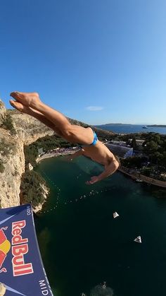 a man diving into the water from a cliff