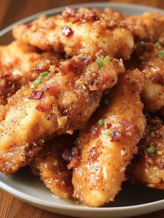 some fried food on a white plate with green onions and seasoning sprinkles