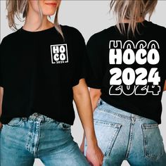 two women wearing black t - shirts that say hoco 2054 and have white letters on them