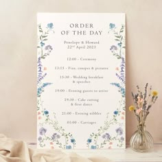 an order of the day sign next to a vase with flowers