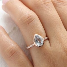 a woman's hand with a diamond ring on top of her finger and an engagement band