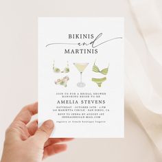 a person holding up a card that says bikinis and martinis