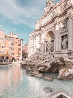 a large fountain in the middle of a city with statues on it's sides