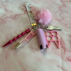 some pink items are laying out on a white table with it's keychain