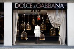 a store front with birdcages and mannequins in the window