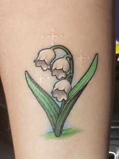 a tattoo with flowers on the side of a woman's leg and cross in the background