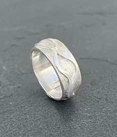 This Sterling Silver band features two Fine Silver waves which run all the way around. The waves are fixed. The band has a wave texture underneath the raised shiny silver wave detail. The band measures approximately: 8mm in width.  Please leave your size needed at Checkout and also whether you used a narrow ring sizer (approximately: 4mm in width or a wide ring sizer measuring approximately: 7mm) This ensures a perfect fit. Adjustable Silver Wavy Rings, Sterling Silver Wavy Promise Ring, Sterling Silver Promise Ring With Wavy Shape, Wavy Silver Jewelry For Anniversary, Silver Wavy Jewelry For Anniversary, Wavy Silver Promise Ring, Sea Ring, Waves Ring, Sea Rings