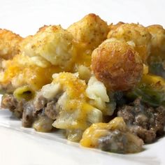 a white plate topped with tater tots covered in cheese and meat mixtures