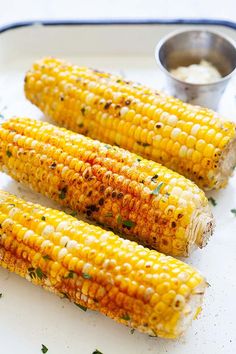 grilled corn on the cob with butter and seasoning sitting on a plate