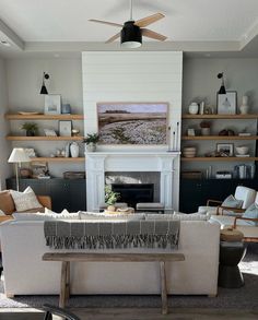 a living room filled with furniture and a fire place in front of a white fireplace