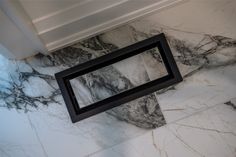 a mirror on the side of a marble wall