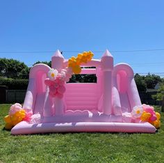 an inflatable pink castle with flowers and balloons