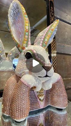 an elaborately decorated rabbit statue in front of a mirror