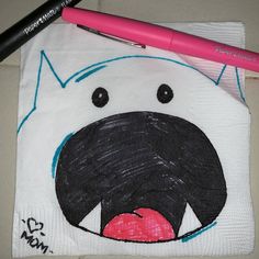 a white bag with a black dog drawn on it next to a pink pen and marker