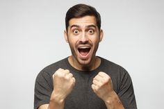 a man with his mouth wide open and fists up in front of him, making an angry face