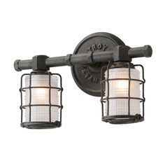 two lights are attached to the side of a light fixture with caged glass shades