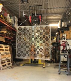 a large piece of metal is hanging in a warehouse with pallets and other items