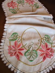 an embroidered table runner with pink flowers on it