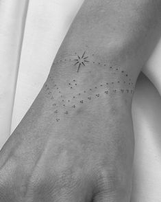 a person with a small star tattoo on their left hand and the stars are all over them