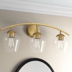 three light bathroom vanity fixture with glass globes and brass finish, in a neutral color scheme