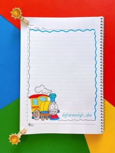 a notepad with a train drawn on it next to a rainbow colored paper background