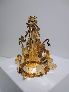 a golden clock is sitting on top of a white box with gold trimmings