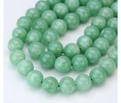 a strand of green jade beads on a white background