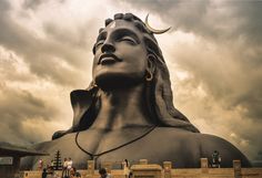 a large buddha statue sitting under a cloudy sky