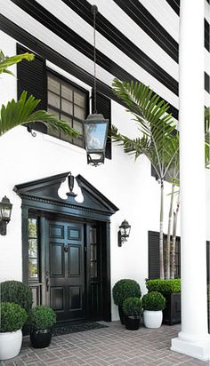 a black and white house with potted plants