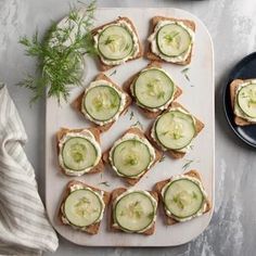 cucumber sandwiches are arranged on a cutting board