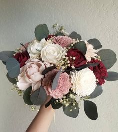 a person holding a bouquet of flowers in their hand