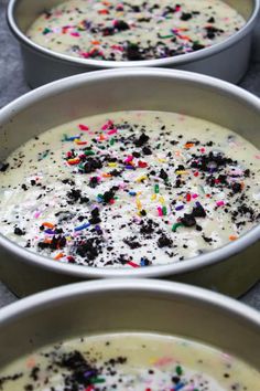 three white bowls filled with cake batter and sprinkles