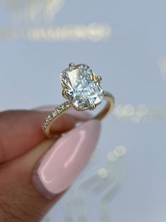 a woman's hand holding an engagement ring with a diamond in the middle and side