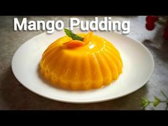 mango pudding on a white plate with the words mango pudding in front of it and an orange garnish