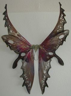 a purple butterfly hanging from the side of a wall