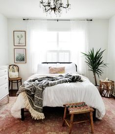 a bedroom with a bed, rugs and a chandelier hanging from the ceiling