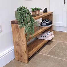 a wooden shelf with plants and shoes on it