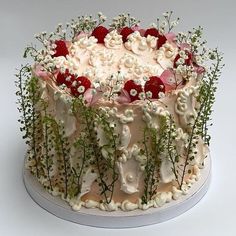 a decorated cake with flowers and berries on top