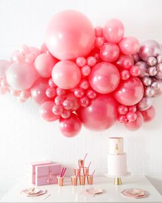 a bunch of balloons floating in the air over a table with other items on it