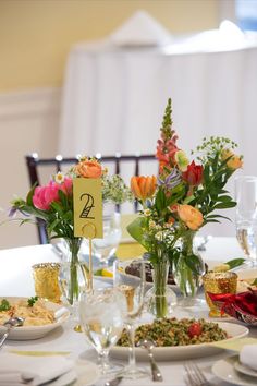 the table is set with flowers and place cards