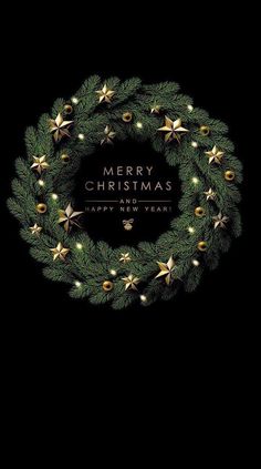 a christmas wreath with lights on it and the words merry christmas written in gold lettering