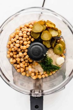 a food processor filled with vegetables and chickpeas