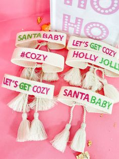 some tassels that are on top of a pink surface with the words ho hoo and let's get cozy