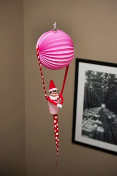 a pink ornament hanging from the ceiling with a santa clause hat on it