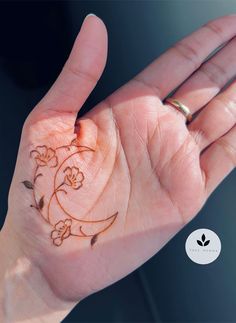 a woman's hand with a small tattoo design on the inside of her palm