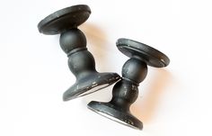 two black knobs on top of each other in the shape of a pair of legs