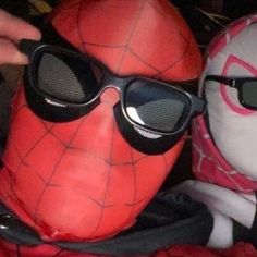 two stuffed animals are wearing sunglasses and one has a spiderman mask on it's head