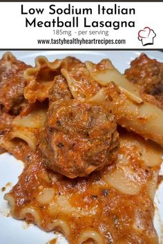 meatball lasagna with pasta and sauce on a white plate in front of the words low sodium italian meatball lasagna